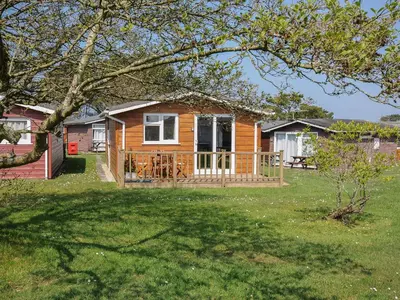 a house with a deck and a yard at Little Trebah in St Merryn