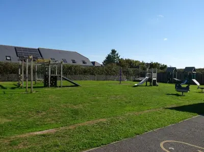an empty playground with a park with swings at Parc Trethias in St Merryn