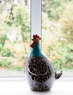 a vase with a flower on a window sill at Spacious flat St Ives former farmhouse, parking in St Ives