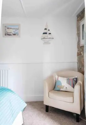 a chair in a room with a pillow on it at Spacious flat St Ives former farmhouse, parking in St Ives