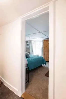a bedroom with a bed and a room with a doorway at Spacious flat St Ives former farmhouse, parking in St Ives