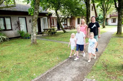 a family walking down a path in a yard at Tolroy Manor Holiday Park in Hayle
