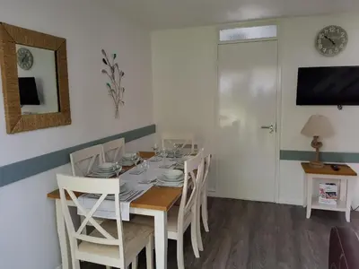 a dining room with a table and white chairs at Tolroy Manor Holiday Park in Hayle