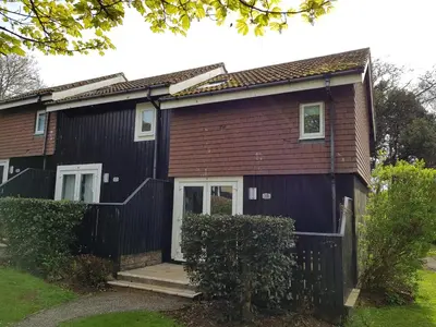 a small house with a black exterior at Tolroy Manor Holiday Park in Hayle