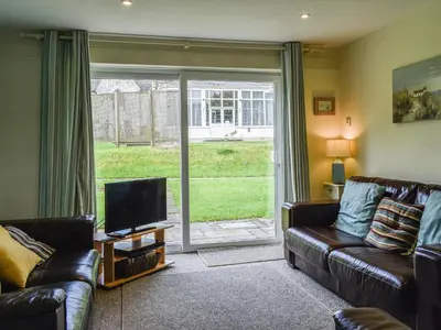 a living room with a couch and a television at Fifty Six in Saint Columb Major