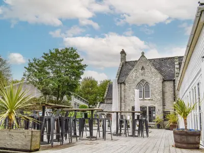 a patio with stools in front of a building at Fifty Six in Saint Columb Major