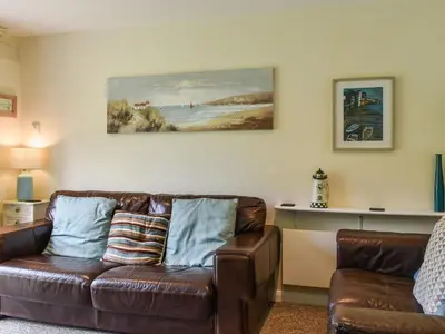 a living room with a brown leather couch at Fifty Six in Saint Columb Major