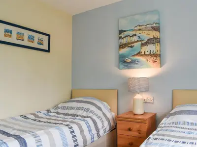 a bedroom with two beds and a painting on the wall at Fifty Six in Saint Columb Major