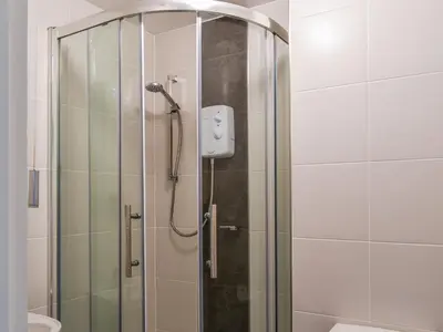 a shower with a glass door in a bathroom at Fifty Six in Saint Columb Major