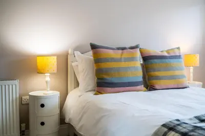 a bedroom with a bed with pillows and two lamps at The Rosevine in Porthscatho