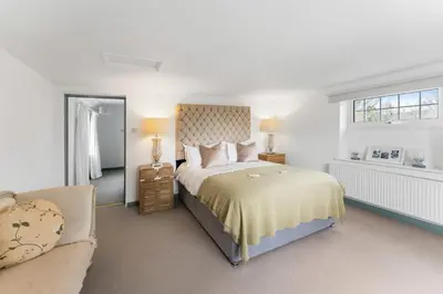 a white bedroom with a bed and a couch at The Rosevine in Porthscatho