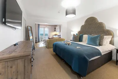 a bedroom with a large bed with a large headboard at The Rosevine in Porthscatho