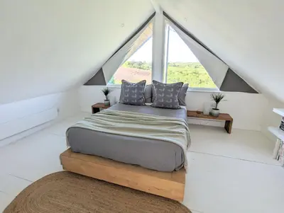 a bedroom with a bed and a large window at Private Double Room and Ensuite in Historic Cornish Cottage in Helston