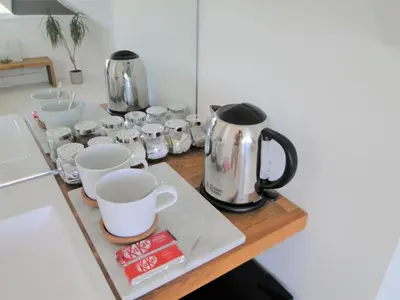 a counter with several cups and a coffee pot on it at Private Double Room and Ensuite in Historic Cornish Cottage in Helston