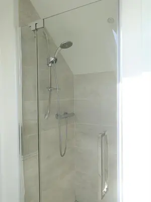 a shower with a glass door in a bathroom at Private Double Room and Ensuite in Historic Cornish Cottage in Helston