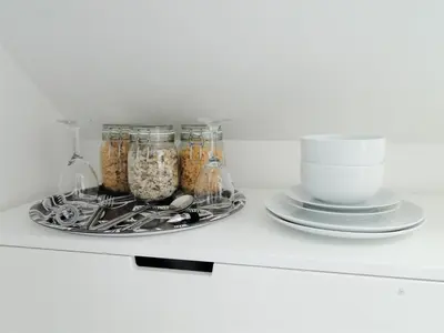 a shelf with jars of food and a plate of dishes at Private Double Room and Ensuite in Historic Cornish Cottage in Helston