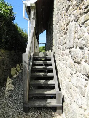 a set of stairs leading up to a stone wall at Private Double Room and Ensuite in Historic Cornish Cottage in Helston
