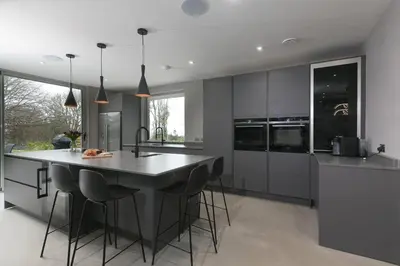 a kitchen with a large island with bar stools at Sparrows Nest in St Ives