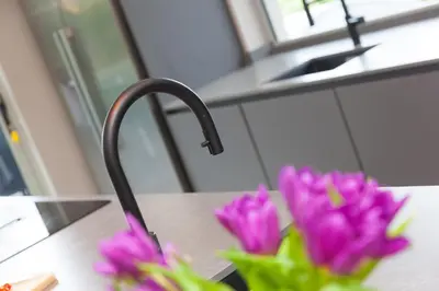 a kitchen counter with a sink and purple flowers at Sparrows Nest in St Ives