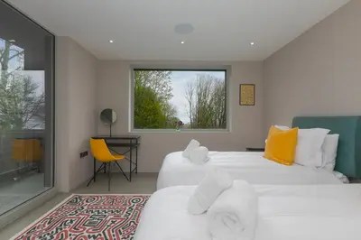 a bedroom with two beds and a window at Sparrows Nest in St Ives