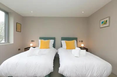 two beds in a room with white and yellow pillows at Sparrows Nest in St Ives