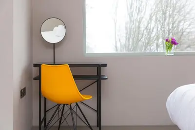 a yellow chair sitting next to a desk in a bedroom at Sparrows Nest in St Ives