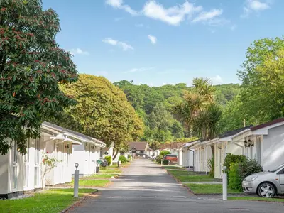 a residential street with white houses and trees at Squirrels Leap in Saint Cleer