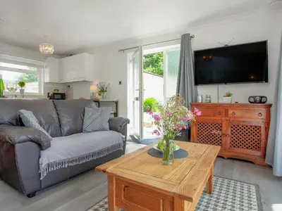 a living room with a couch and a table at Squirrels Leap in Saint Cleer