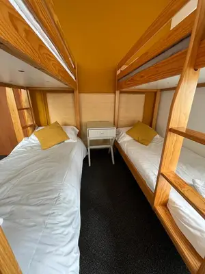 a room with two bunk beds and a table at Elemental Surf Lodge in Newquay
