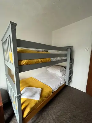 a bedroom with a bunk bed with a yellow blanket at Elemental Surf Lodge in Newquay