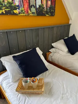 two beds in a room with two bowls on a tray at Elemental Surf Lodge in Newquay