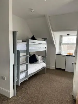a bedroom with two bunk beds and a window at Elemental Surf Lodge in Newquay