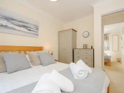 a bedroom with two beds with white pillows at Woodmans Cottage in Falmouth