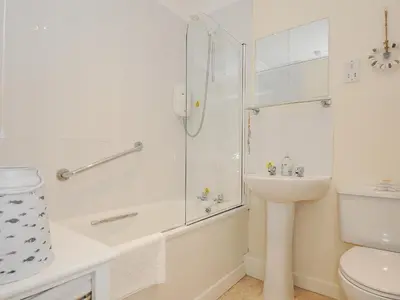 a bathroom with a shower and a sink and a toilet at Woodmans Cottage in Falmouth