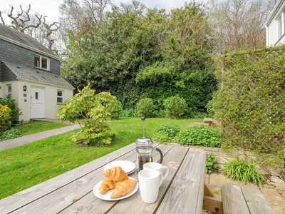 a table with two plates of croissants and cups at Woodmans Cottage in Falmouth
