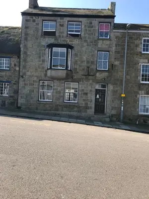 a brick building with windows on the side of a street at No 52 bed and breakfast in Helston