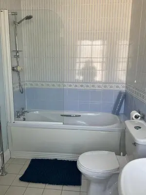 a bathroom with a tub and a toilet and a sink at No 52 bed and breakfast in Helston