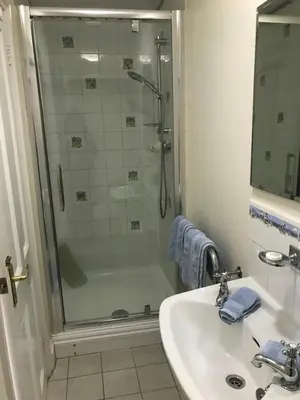 a bathroom with a glass shower and a sink at No 52 bed and breakfast in Helston
