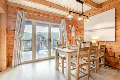 a dining room with a table and chairs and a large window at 3 Bed in Wadebridge oc-p00104 in Little Petherick