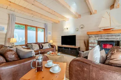 a living room with leather furniture and a fireplace at 3 Bed in Wadebridge oc-p00104 in Little Petherick