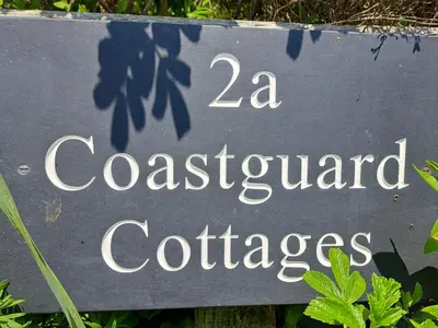 a sign for a garden of cottages at 2a Coastguard Cottages in Gorran Haven
