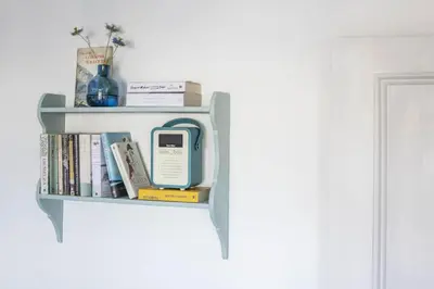 a book shelf with a cell phone and books at 3 Bed in Porthleven oc-12bayv in Porthleven