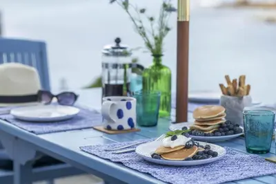 a table topped with plates of pancakes and blueberries at 3 Bed in Porthleven oc-12bayv in Porthleven