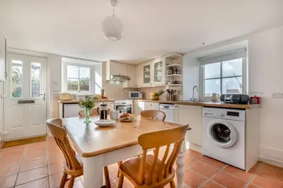 a kitchen with a wooden table and chairs and a sink at 1 Bed in Rinsey oc-1chapl in Praa Sands