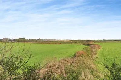 a field of green grass with a blue sky at 1 Bed in Rinsey oc-1chapl in Praa Sands
