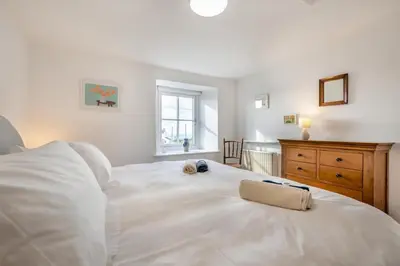 a bedroom with a large white bed with a towel on it at 1 Bed in Rinsey oc-1chapl in Praa Sands