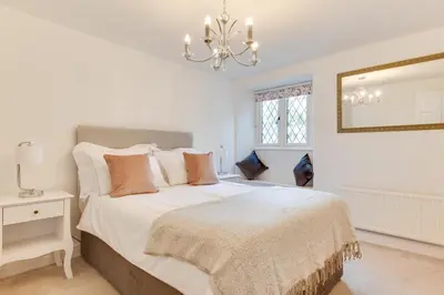 a bedroom with a large white bed with a chandelier at 3 Bed in Fowey oc-1cobbs in Fowey