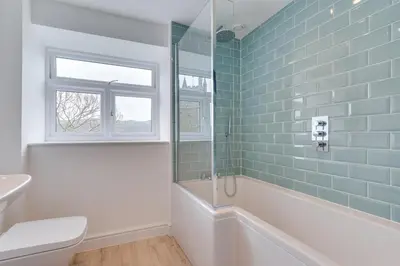 a bathroom with a tub and a toilet and a window at 3 Bed in Fowey oc-1cobbs in Fowey