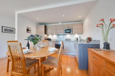 a kitchen and dining room with a wooden table and chairs at 2 Bed in Porthleven oc-1mont in Porthleven