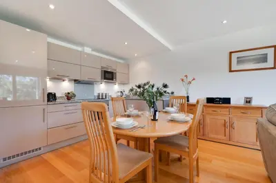 a kitchen and dining room with a wooden table and chairs at 2 Bed in Porthleven oc-1mont in Porthleven